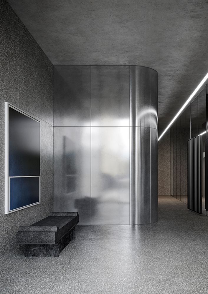 Silver stainless steel wall panels wrapping a curved lobby wall.