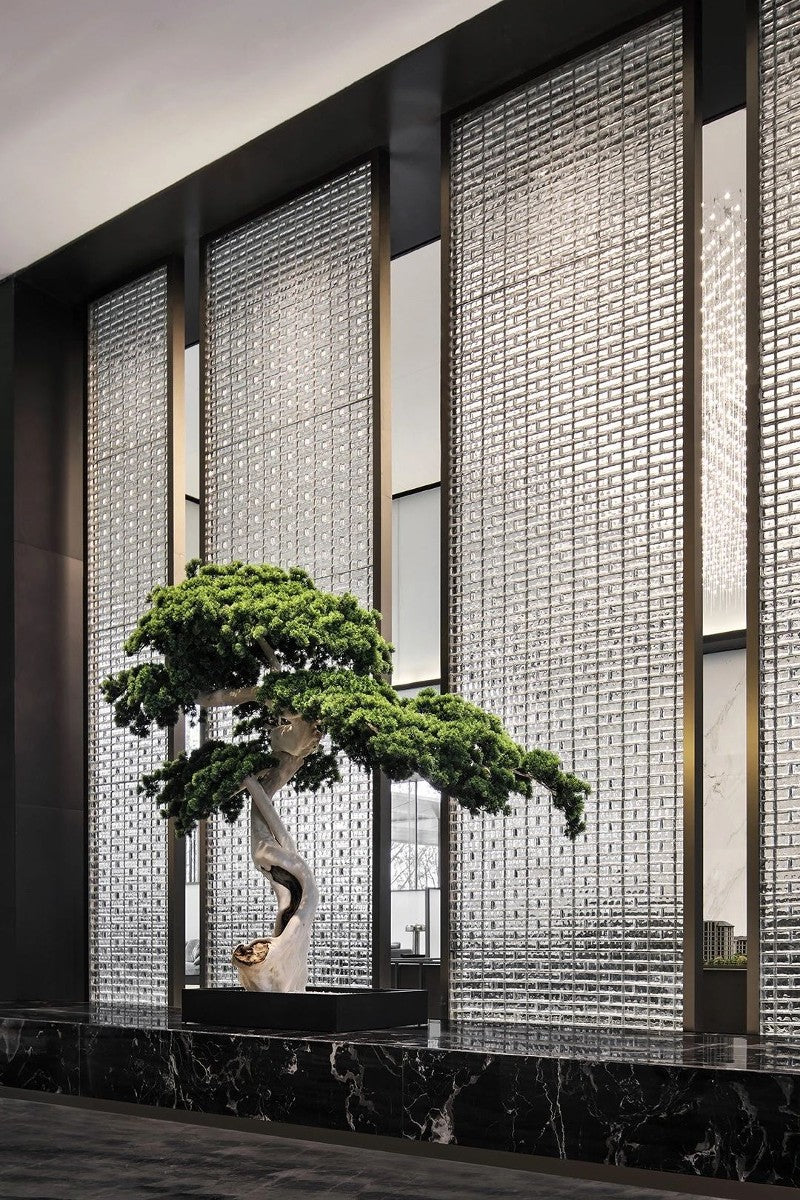 Silver-toned stainless steel mesh screen panels forming a tall lobby divider.