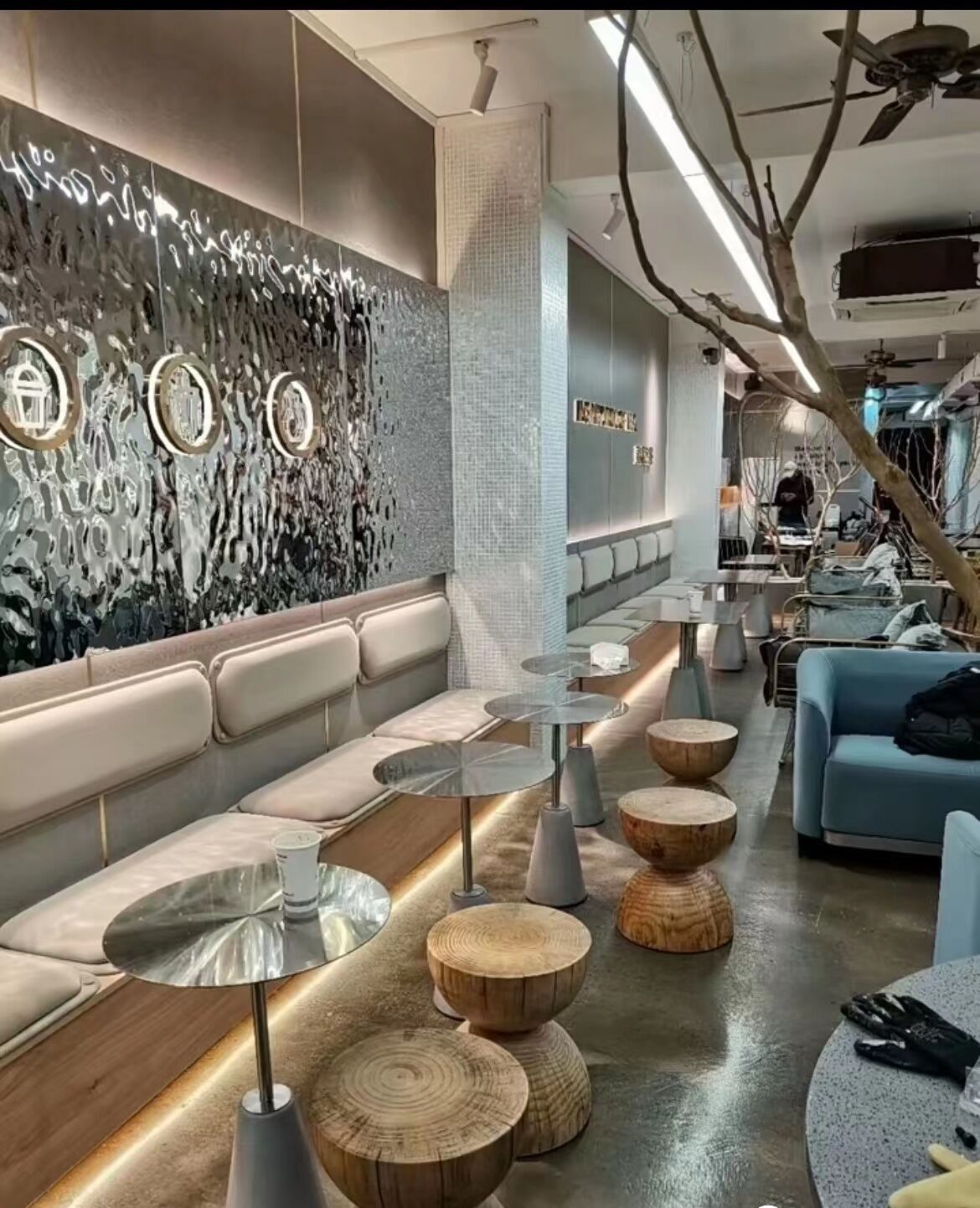 Silver water ripple stainless steel wall panels lining a restaurant lounge.